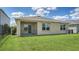 Exterior view of the house showcasing the screened-in lanai and grassy backyard with partial fencing at 17119 Barnwood Pl, Bradenton, FL 34211