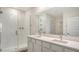Modern bathroom with double vanity sinks, quartz countertop, and a glass-enclosed shower with tile surround at 17119 Barnwood Pl, Bradenton, FL 34211