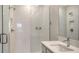 Modern bathroom with glass shower featuring white tiles and a sleek vanity with a built-in sink at 17119 Barnwood Pl, Bradenton, FL 34211