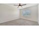 Cozy bedroom with neutral carpet, a ceiling fan, a window, and a spacious closet at 17119 Barnwood Pl, Bradenton, FL 34211