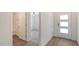 Hallway with views to a bathroom and bedroom. The front door has three glass panes for extra light at 17119 Barnwood Pl, Bradenton, FL 34211