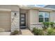 Modern home exterior featuring stone accents, a contemporary front door with windows, and a manicured landscape at 17119 Barnwood Pl, Bradenton, FL 34211