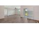 Open living room with wood-look flooring, ceiling fan, and sliding glass doors to the outdoor patio at 17119 Barnwood Pl, Bradenton, FL 34211