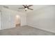 Spacious main bedroom featuring neutral carpet, a ceiling fan, a walk-in closet, and an en-suite bathroom at 17119 Barnwood Pl, Bradenton, FL 34211