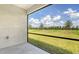 View from covered patio, showcasing the expansive backyard and clear blue sky with fluffy white clouds at 17119 Barnwood Pl, Bradenton, FL 34211