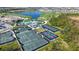Aerial view showcasing the community's tennis courts, pool, lake, golf course, and clubhouse for active lifestyles at 17449 Sandpearl Rd, Venice, FL 34293