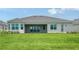 Spacious backyard with lush green grass and a covered patio, perfect for outdoor living and entertaining at 17449 Sandpearl Rd, Venice, FL 34293