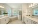 Spacious bathroom with dual vanities, a soaking tub, and a glass-enclosed shower at 17449 Sandpearl Rd, Venice, FL 34293