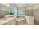 Bright bathroom featuring dual vanities, a garden tub, and glass shower at 17449 Sandpearl Rd, Venice, FL 34293