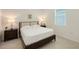 Neutral bedroom featuring side tables, lamps, and tile flooring at 17449 Sandpearl Rd, Venice, FL 34293