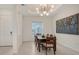 Bright dining room with modern light fixture, artwork, and a table with seating for six at 17449 Sandpearl Rd, Venice, FL 34293