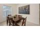 Bright dining room with modern light fixture, artwork, and a table with seating for six at 17449 Sandpearl Rd, Venice, FL 34293