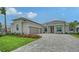 Charming home featuring a brick driveway, well-manicured lawn, attached two-car garage and beautiful landscaping at 17449 Sandpearl Rd, Venice, FL 34293