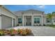 Charming home featuring a brick driveway, well-manicured lawn, attached two-car garage and beautiful landscaping at 17449 Sandpearl Rd, Venice, FL 34293