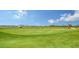 Lush green golf course with golfers enjoying a sunny day in a scenic community setting at 17449 Sandpearl Rd, Venice, FL 34293