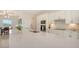 Open-concept kitchen featuring white cabinetry, stainless steel appliances, and a large quartz countertop island at 17449 Sandpearl Rd, Venice, FL 34293