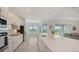 Well-lit kitchen showcasing white cabinetry, sleek countertops, and a seamless flow to the living area at 17449 Sandpearl Rd, Venice, FL 34293