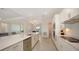Bright kitchen features white cabinetry, stainless steel appliances, and an open layout connecting living areas at 17449 Sandpearl Rd, Venice, FL 34293