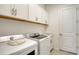 Well-organized laundry room with white cabinets, countertop space, and modern washer and dryer for efficient laundry care at 17449 Sandpearl Rd, Venice, FL 34293