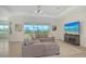 Bright living room featuring neutral tile floors, modern lighting, and large sliding doors to lanai at 17449 Sandpearl Rd, Venice, FL 34293