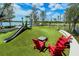 Fun-filled community playground featuring a slide, swings, and cozy seating areas perfect for families at 17449 Sandpearl Rd, Venice, FL 34293