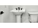 Classic bathroom with white pedestal sink and toilet at 17927 Palmiste Dr, Bradenton, FL 34202