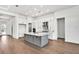 Open-concept kitchen featuring a center island, stainless steel appliances, custom cabinets, and hardwood flooring at 17927 Palmiste Dr, Bradenton, FL 34202