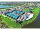 An aerial view of the community pickleball courts and lounge area next to a scenic lake at 19038 Lappacio St, Venice, FL 34293