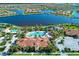 Aerial view of the community clubhouse with a pool and surrounding amenities, including a lake at 19038 Lappacio St, Venice, FL 34293