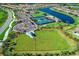 Aerial view of community amenities including dog park, tennis courts, pool, and clubhouse, all adjacent to a scenic waterway at 19038 Lappacio St, Venice, FL 34293