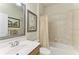 Bright bathroom featuring a tub-shower combination with decorative curtain, framed art, and vanity at 19038 Lappacio St, Venice, FL 34293
