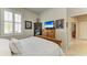 Bedroom featuring neutral walls, shutters, and a wooden dresser with TV at 19038 Lappacio St, Venice, FL 34293