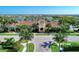 An inviting clubhouse with lush landscaping and paved entrance surrounded by tropical trees at 19038 Lappacio St, Venice, FL 34293