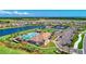Aerial view of a community showing the pool, tennis courts, and a scenic pond with beautiful landscaping at 19038 Lappacio St, Venice, FL 34293