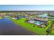 Aerial view of a beautiful community with scenic pond, pool, clubhouse, manicured lawn and tennis courts at 19038 Lappacio St, Venice, FL 34293