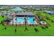 Aerial view of an exclusive community with a large pool and scenic pond surrounded by lush landscaping and stylish homes at 19038 Lappacio St, Venice, FL 34293