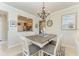 Charming dining room featuring wood table with gray cushioned chairs, chandelier, and nautical decor at 19038 Lappacio St, Venice, FL 34293