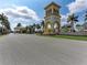 Impressive community entrance with a decorative tower, manicured landscaping, and a guard house at 19038 Lappacio St, Venice, FL 34293