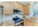 Kitchen with stainless steel appliances, granite countertops and light wood cabinetry at 19038 Lappacio St, Venice, FL 34293