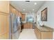 Spacious kitchen featuring stainless steel appliances, light wood cabinetry and an open layout at 19038 Lappacio St, Venice, FL 34293