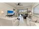 Bright living room featuring comfortable sofas, tile flooring, and sliding glass doors to the patio at 19038 Lappacio St, Venice, FL 34293