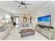 Open-concept living area with comfortable sofas, entertainment center, and dining area in the background at 19038 Lappacio St, Venice, FL 34293