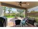 Screened patio with outdoor seating, a ceiling fan, and a view of the well-manicured backyard at 19038 Lappacio St, Venice, FL 34293