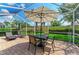 Screened in lanai with brick patio, featuring a table, chairs, umbrella, and lounge seating at 19038 Lappacio St, Venice, FL 34293