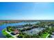 Scenic aerial view of well-maintained tennis courts with a lake backdrop and lush landscaping at 19038 Lappacio St, Venice, FL 34293