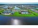 Aerial view of a community with well-maintained tennis courts, pools, landscaping, and surrounding waterways at 19038 Lappacio St, Venice, FL 34293