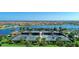 Aerial view showcasing multiple tennis courts alongside a serene lake and the surrounding neighborhood at 19038 Lappacio St, Venice, FL 34293