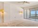 Bright bedroom with carpet, wall sconces, and sliding glass doors to a balcony with ocean views at 20 Whispering Sands Dr # 1201, Sarasota, FL 34242
