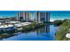 Exterior shot of the condominium community, with a tranquil lake in the foreground and the beach in the background at 20 Whispering Sands Dr # 1201, Sarasota, FL 34242