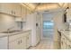 An open kitchen features white appliances, tiled floors, and a view of the ocean at 20 Whispering Sands Dr # 1201, Sarasota, FL 34242
